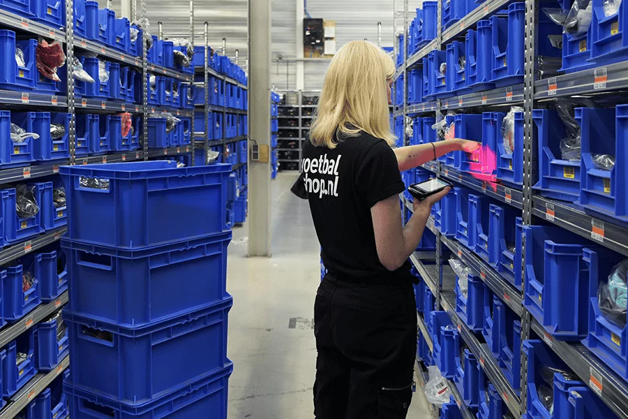 Voetbalshop.nl-medewerker beheert magazijnvoorraad met Sherpa WMS – slimme replenishment en voorraadcontrole.